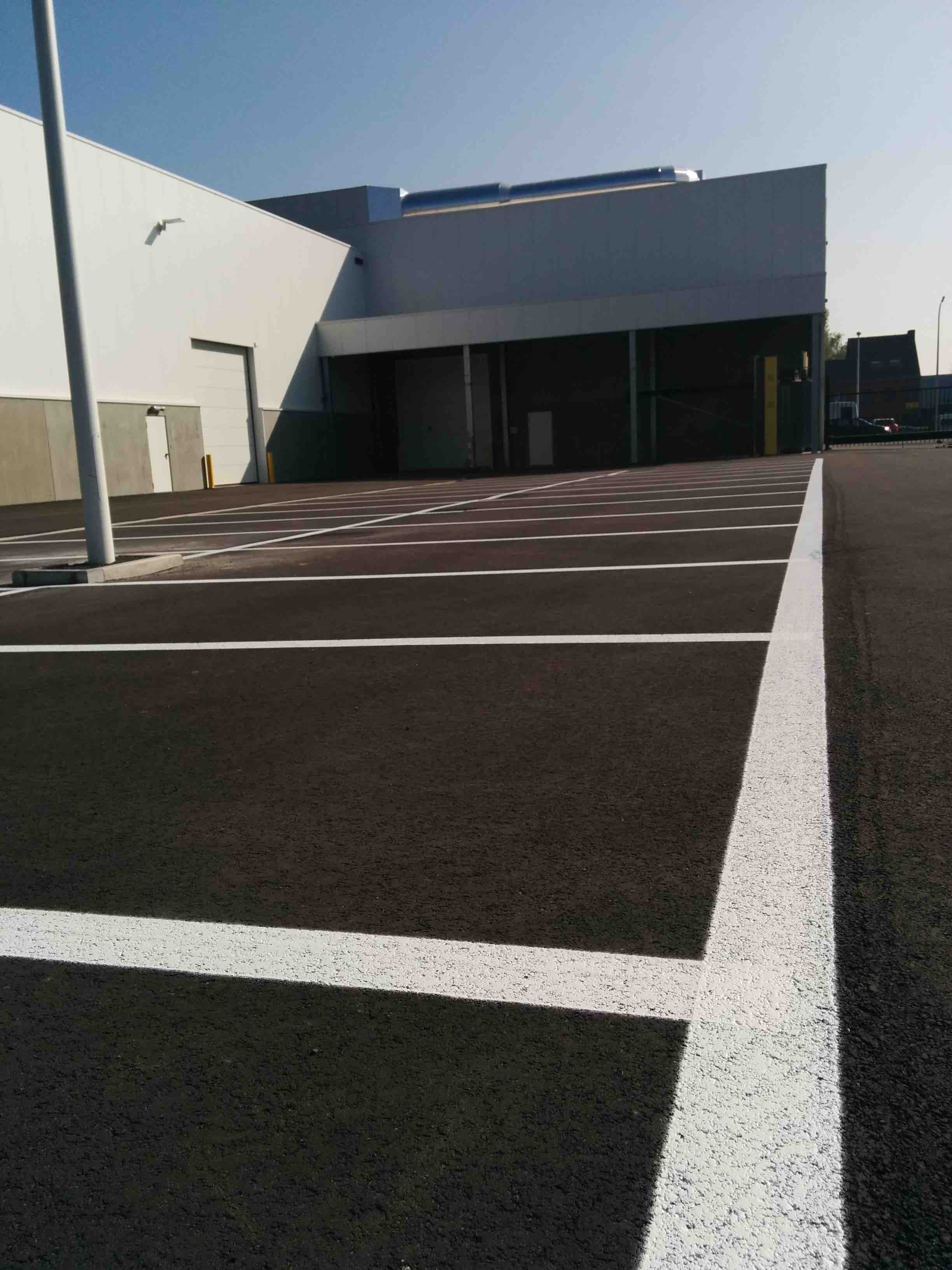Vers wit zebrapad op betonnen toegangsweg van een industrieterrein