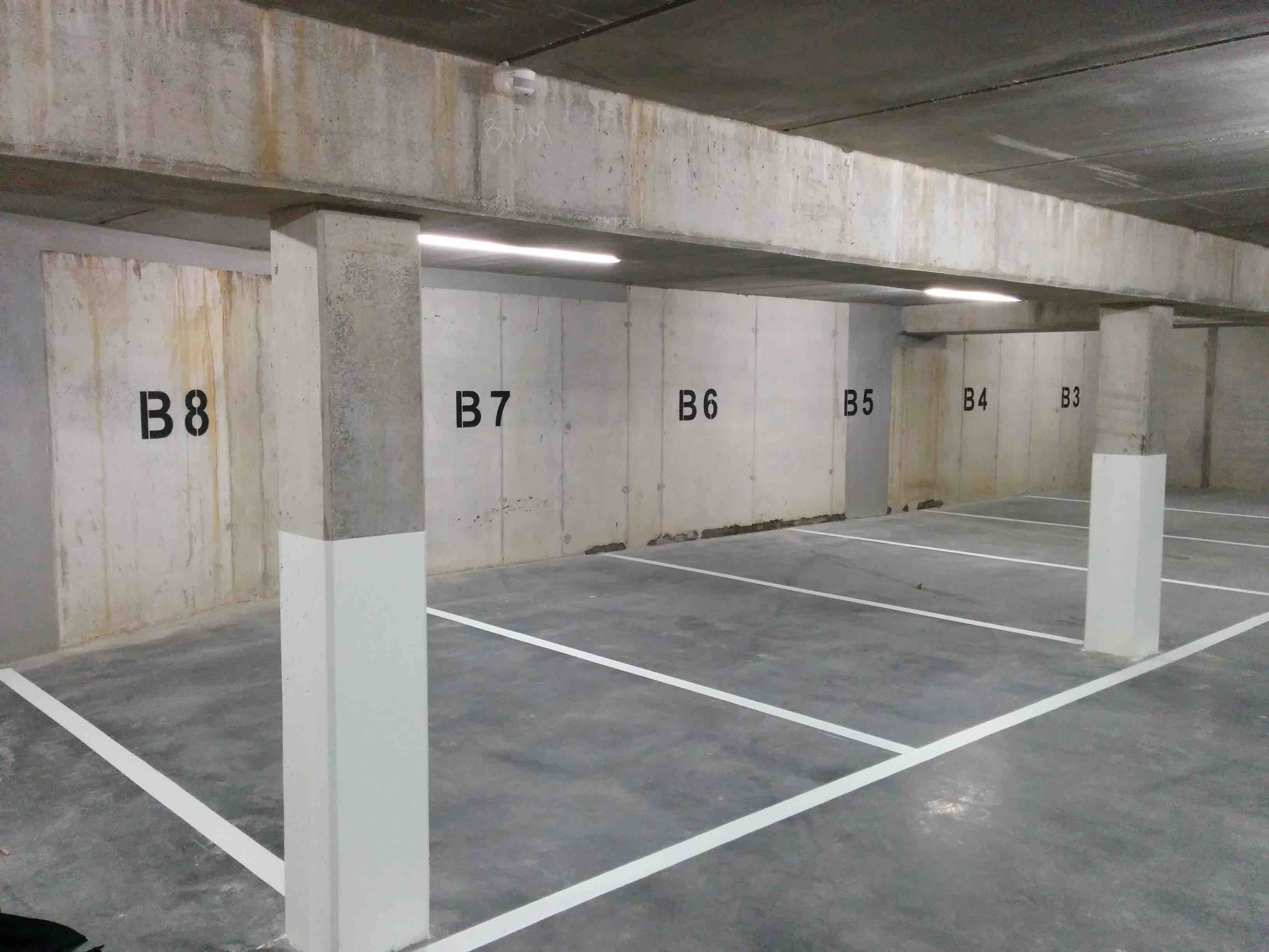 Witte belijning op betonnen ondergrond — typisch voor privé-oprit en garagevloer